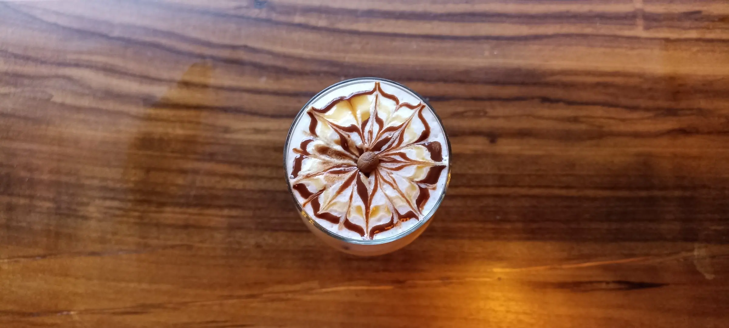 Café con arte de caramelo sobre una mesa de madera en Café EKA, Montenegro, Quindío